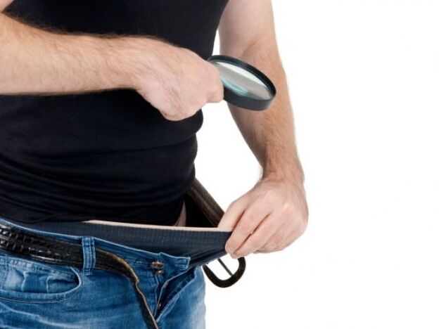 Un homme baisse les yeux sur son pantalon et veut agrandir son pénis
